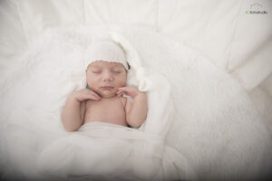 neonato con cuffietta bianca